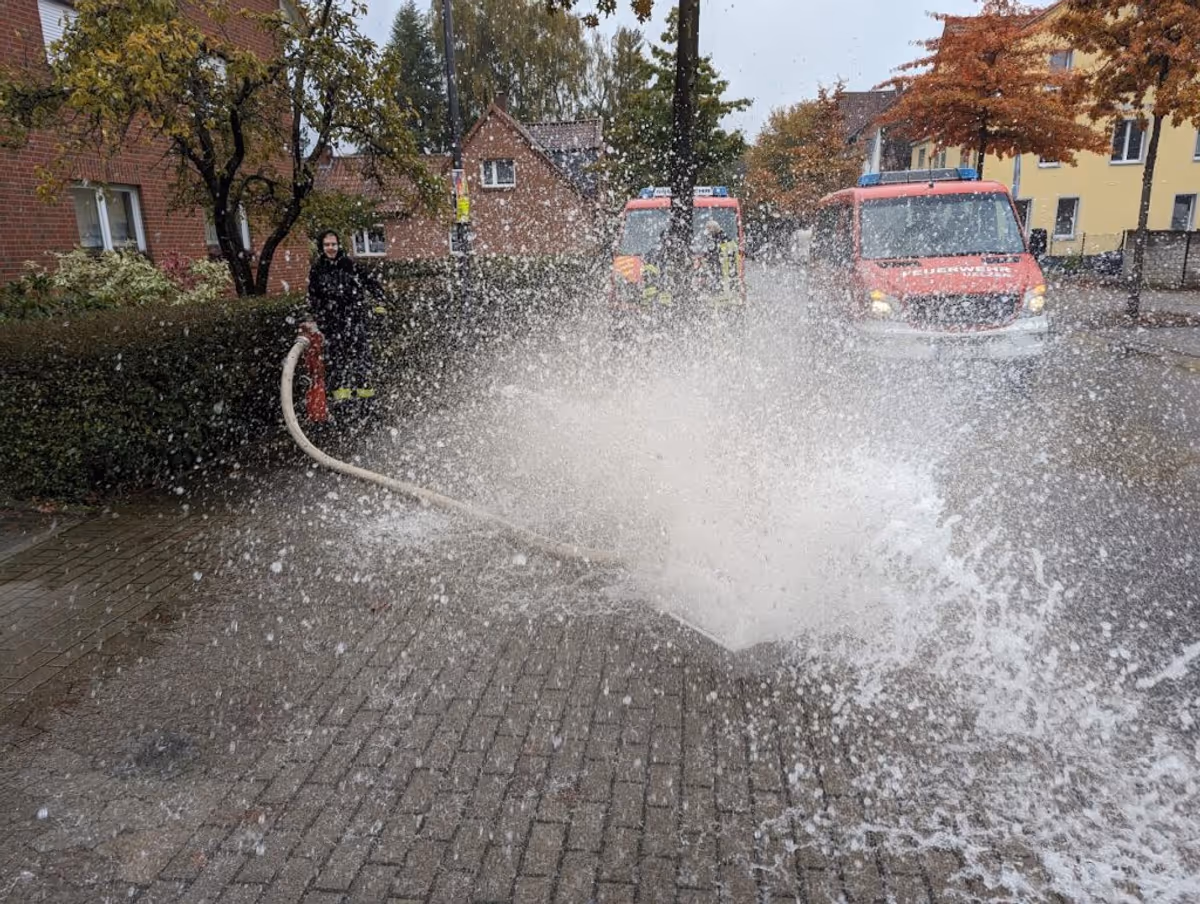 Ein Hydrant wird gespült mit der Hilfe eines Spülkastens. Das Wasser spritzt kontrolliert aus dem Spülkasten, doch aufgrund des hohen Drucks ist es Fontänenartig.